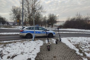 zdjęcie przedstawia hulajnogi elektryczne stojące obok radiowozu.