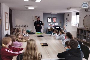 zdjęcie przedstawia policjanta w trakcie prelekcji dla dzieci