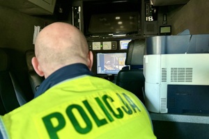 zdjęcie przedstawia policjantów w trakcie kontroli drogowej