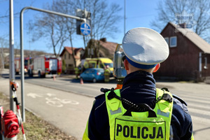 zdjęcie przedstawia policjanta w trakcie czynności na miejscu wypadku