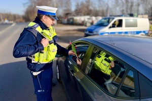 zdjęcie przedstawia policjantów w trakcie kontroli drogowej.