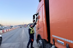 zdjęcie przedstawia policjanta w trakcie kontroli trzeźwości kierującego.