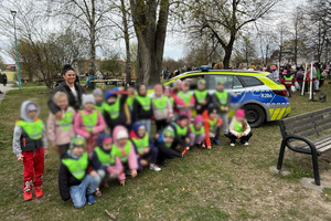 policjanci na pikniku pokazują policyjne pojazdy dzieciom