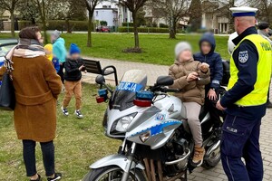 policjanci na pikniku pokazują policyjne pojazdy dzieciom