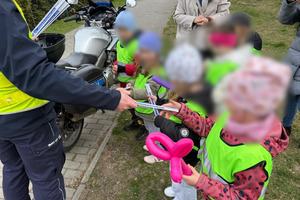 policjanci na pikniku pokazują policyjne pojazdy dzieciom