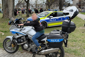 policjanci na pikniku pokazują policyjne pojazdy dzieciom