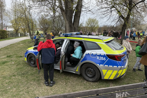 policjanci na pikniku pokazują policyjne pojazdy dzieciom