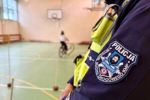 policjant w trakcie egzaminu praktycznego na kartę rowerową obserwuje przejazd dziecka na rowerze.