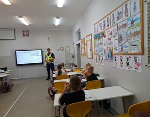 Policjant ruchu drogowego podczas spotkania z uczniami Szkoły Podstawowej nr 10 w Mysłowicach omawiał nowe przepisy dotyczące obowiązkowego używania kasków ochronnych przez osoby do 16. roku życia.