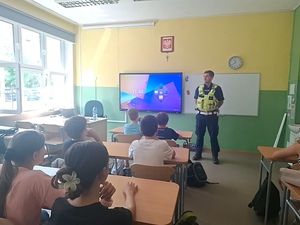 Policjant ruchu drogowego podczas spotkania z uczniami Szkoły Podstawowej nr 10 w Mysłowicach omawiał nowe przepisy dotyczące obowiązkowego używania kasków ochronnych przez osoby do 16. roku życia.