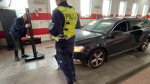 Policjant i diagnosta sprawdzają oświetlenie samochodu