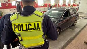 Policjant i diagnosta sprawdzają oświetlenie samochodu